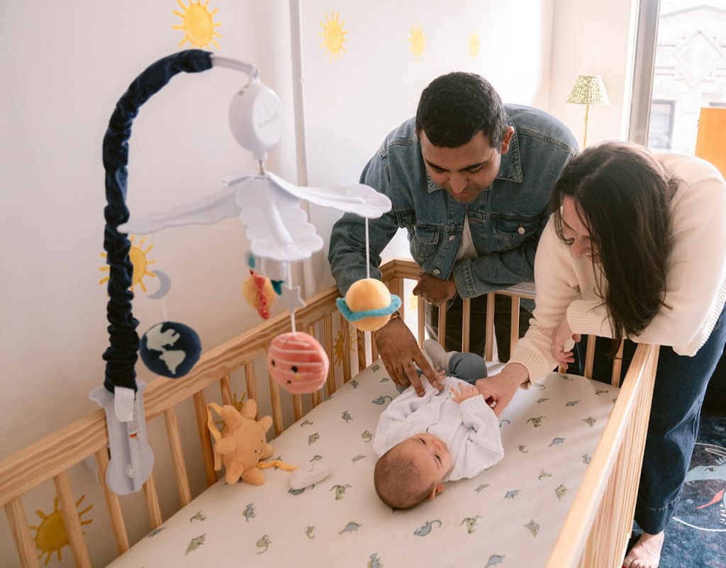 An interfaith family — father, mother, and baby son — reading the Forebear Diwali book together